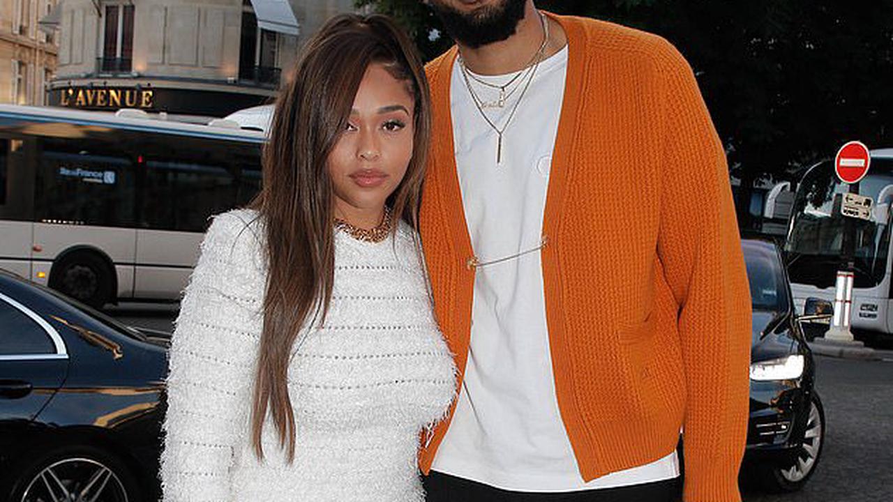 Jordyn Woods looks chic in a white knitted mini dress with a feathered trim as she steps out with boyfriend Karl-Anthony Towns to Dior dinner during Paris Fashion Week