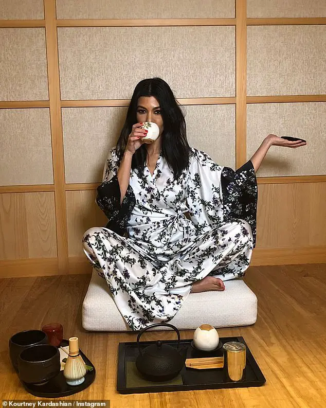 Cultured: For another pose in a chic black and white kimono robe, she delicately sipped her tea and flaunted her red nails, as she styled her dark tresses in waves