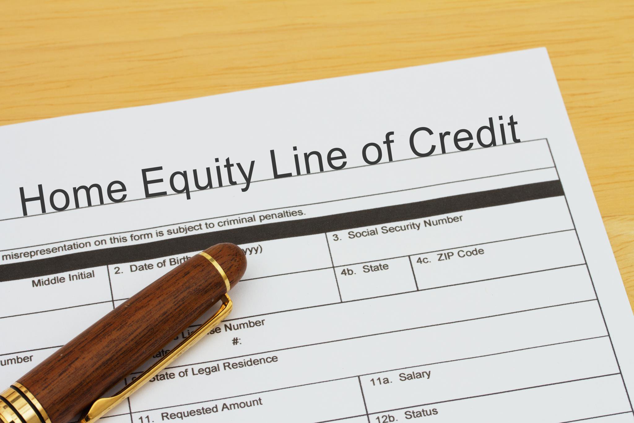 A Home Equity Line of Credit application form with a pen resting on it.