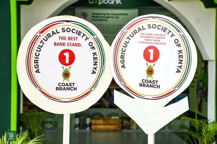 May be an image of text that says 'PocK កុរ BANKSTAND. BANK THE STAND THAT BEST SOCIETY CURRENT THE SOCIETY BEST NTERPRETS SHOW THEME STAND. OF OF 1 E ANヨン e AGRICULT AGRICULTURAL E)FINANCIALINDUSTRY E) FINANCIAL INDUSTRY INTERPRETSCURRENT 1 EN KENYA COAST COAST BRANCH BRANCH ထိ bank'
