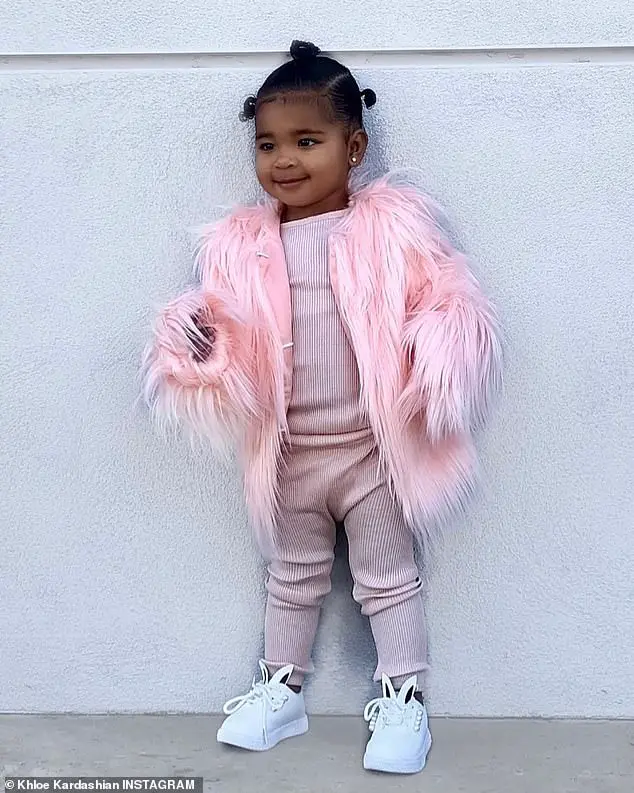 Adorable: True was dressed in a blush pink cotton top and pants combo. Khloe dressed her with a pink feather coat over the top