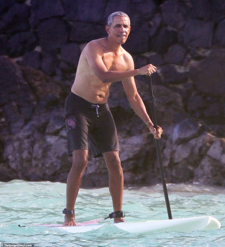 Shirtless Barack Obama shows off his fit physique during a paddle board session while on vacation in Hawaii (Photos)