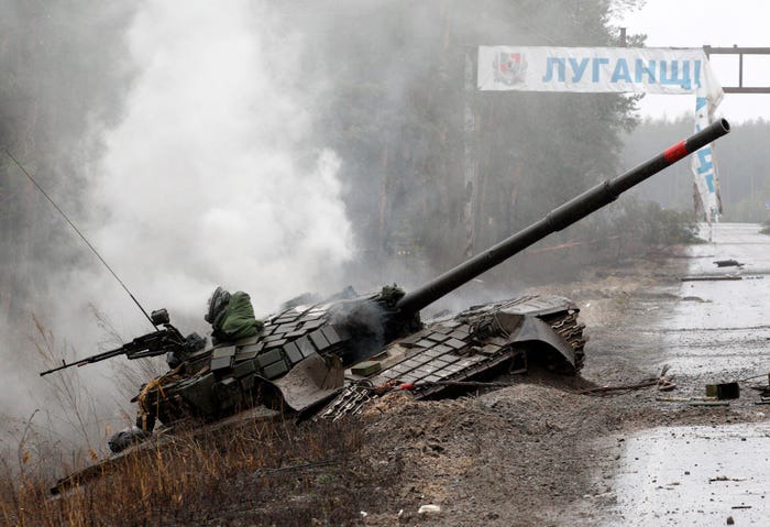 Smoke rises from a Russian tank destroyed by the Ukrainian forces on the side of a road in Lugansk region.