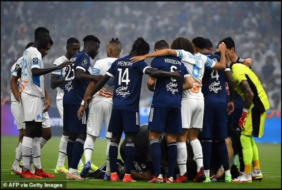 Bordeaux and Marseille players form a human shield around Samuel Kalu after the Super Eagles star collapsed on the pitch