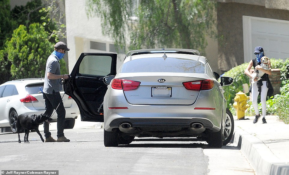Harry walked the couple's female black labrador, Oz, while Meghan at one point carried her beloved rescue beagle, Guy after stepping out of their Porsche SUV