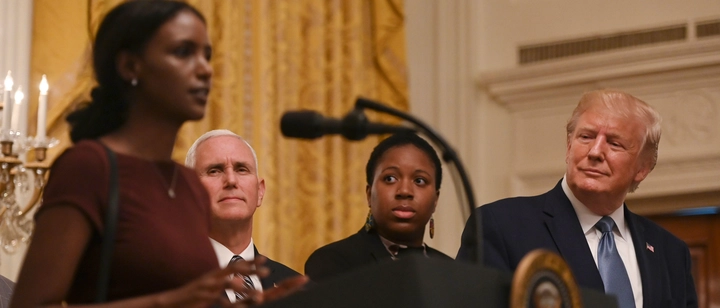 President Donald Trump (R) and Vice President Mike Pence (2-L) listen to a prayer on stage during the Young Black Leadership Summit. ANDREW CABALLERO-REYNOLDS/AFP/Getty Images