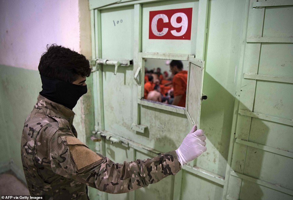 A member of the Syrian Democratic Forces (SDF) stands guard in a prison where men suspected of being affiliated with the Islamic State group are jailed