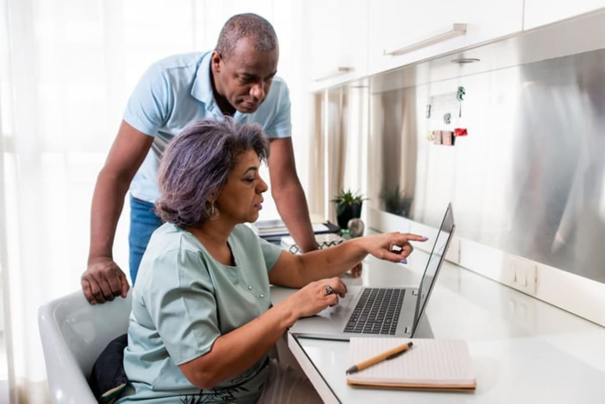 Couple discussing something on laptop together.