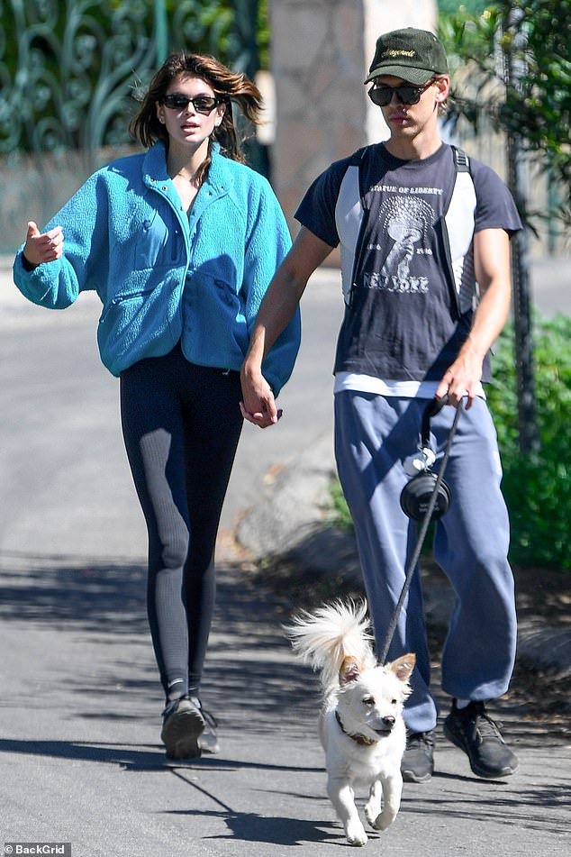 Kaia Gerber and boyfriend Austin Butler hold hands as they take his dog