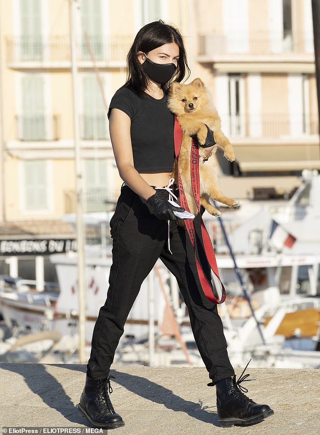 Casual: The model, 19, who was famously dubbed 'the most beautiful girl in the world' when she made her fashion debut as a child, took precautions with the black mask and matching gloves while taking in her daily exercise