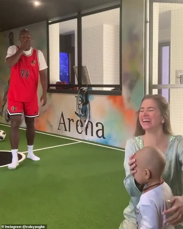 Pogba and his girlfriend laugh after the toilet roll accidentally strikes the face of their baby boy
