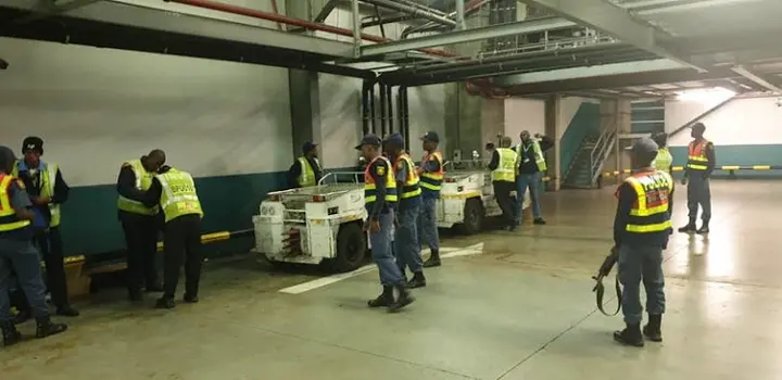 SAPS and security officers conducting a stop-and-search operation in one of the baggage handling areas.