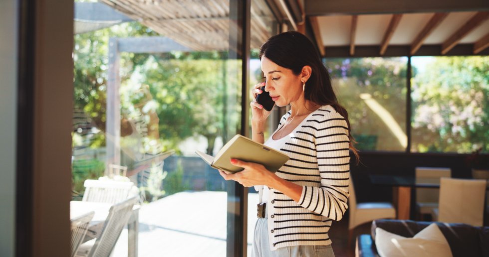 Phone call, notebook and woman by window in home for remote work, virtual assistant and admin help. Communication, freelance and person on smartphone for contact, schedule and confirm appointment