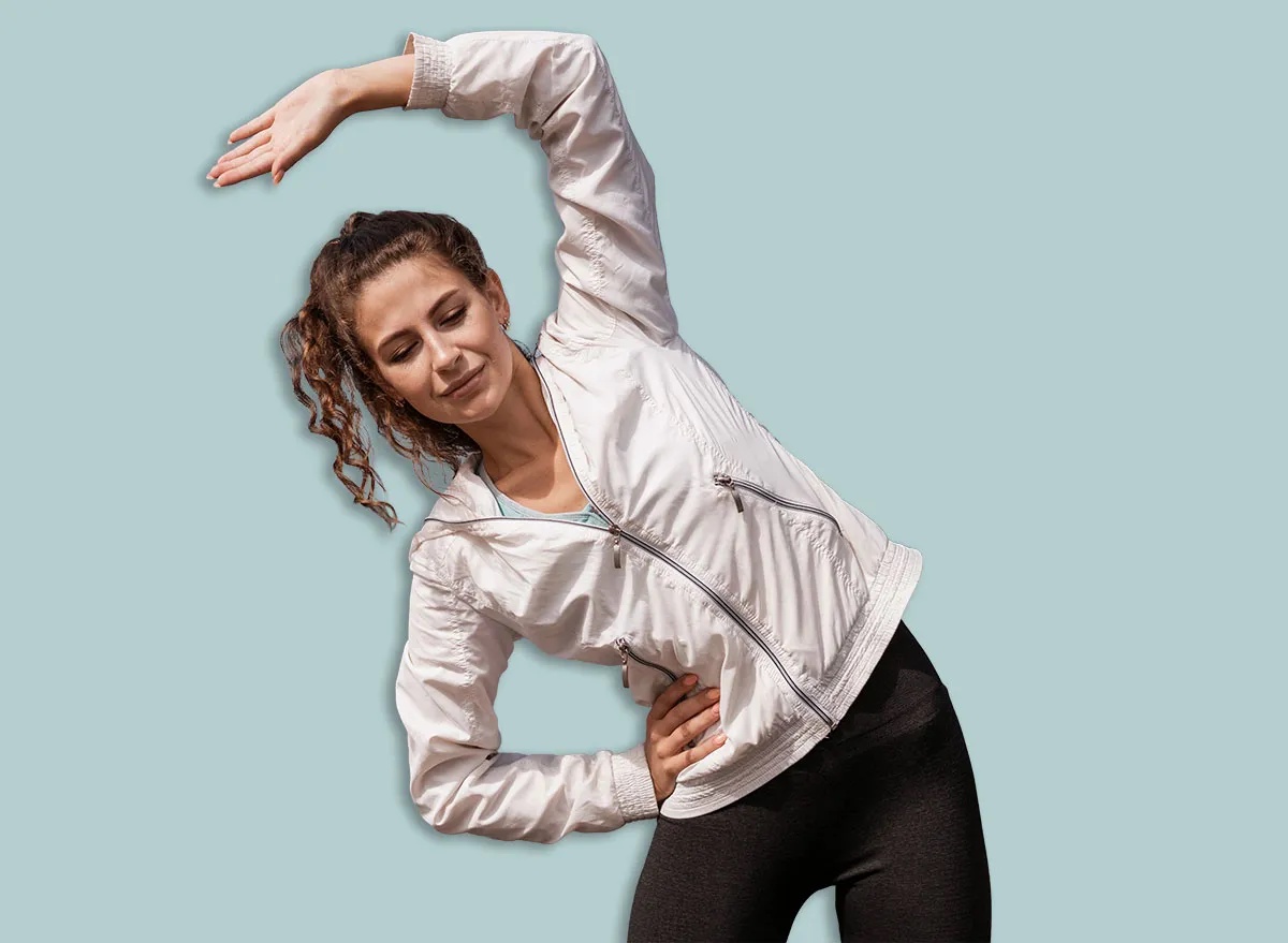 Outdoor fitness in the city. Healthy lifestyle. Coach exercises on the street. A confident woman does a workout. An athlete in comfortable sportswear.