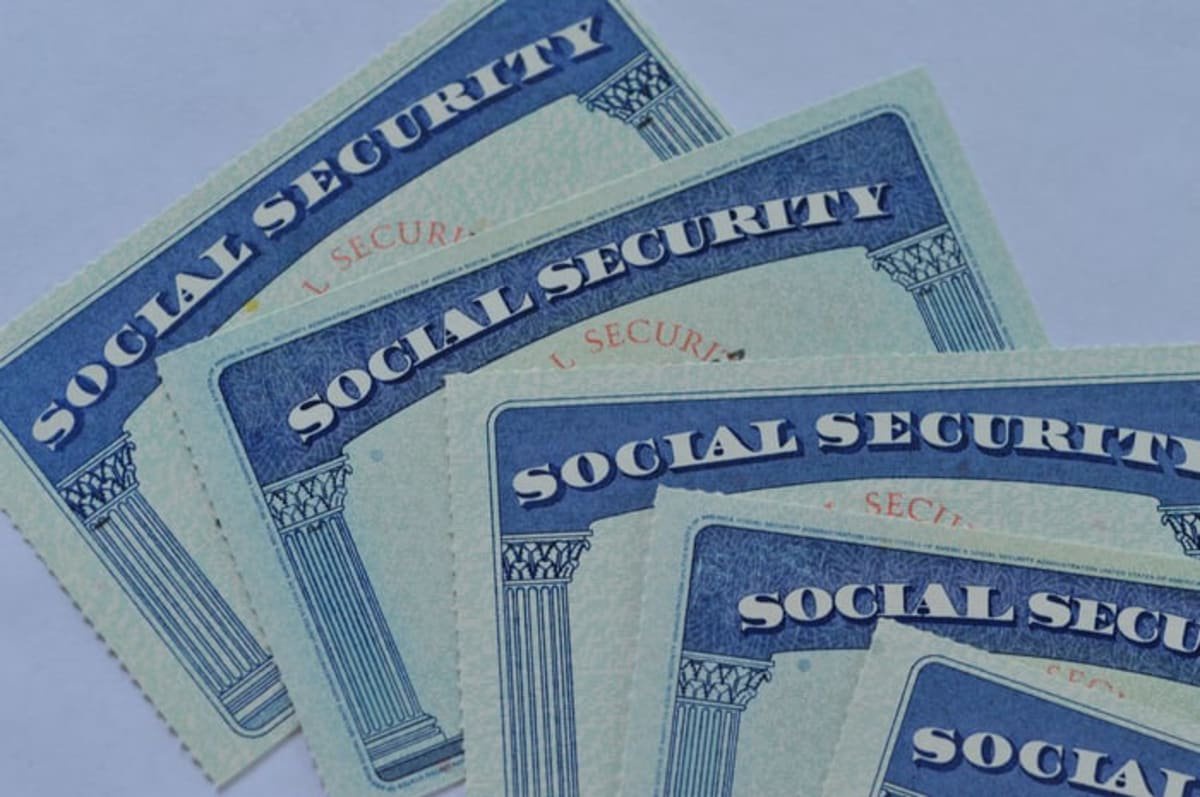 Several overlapping U.S. Social Security cards on a light background