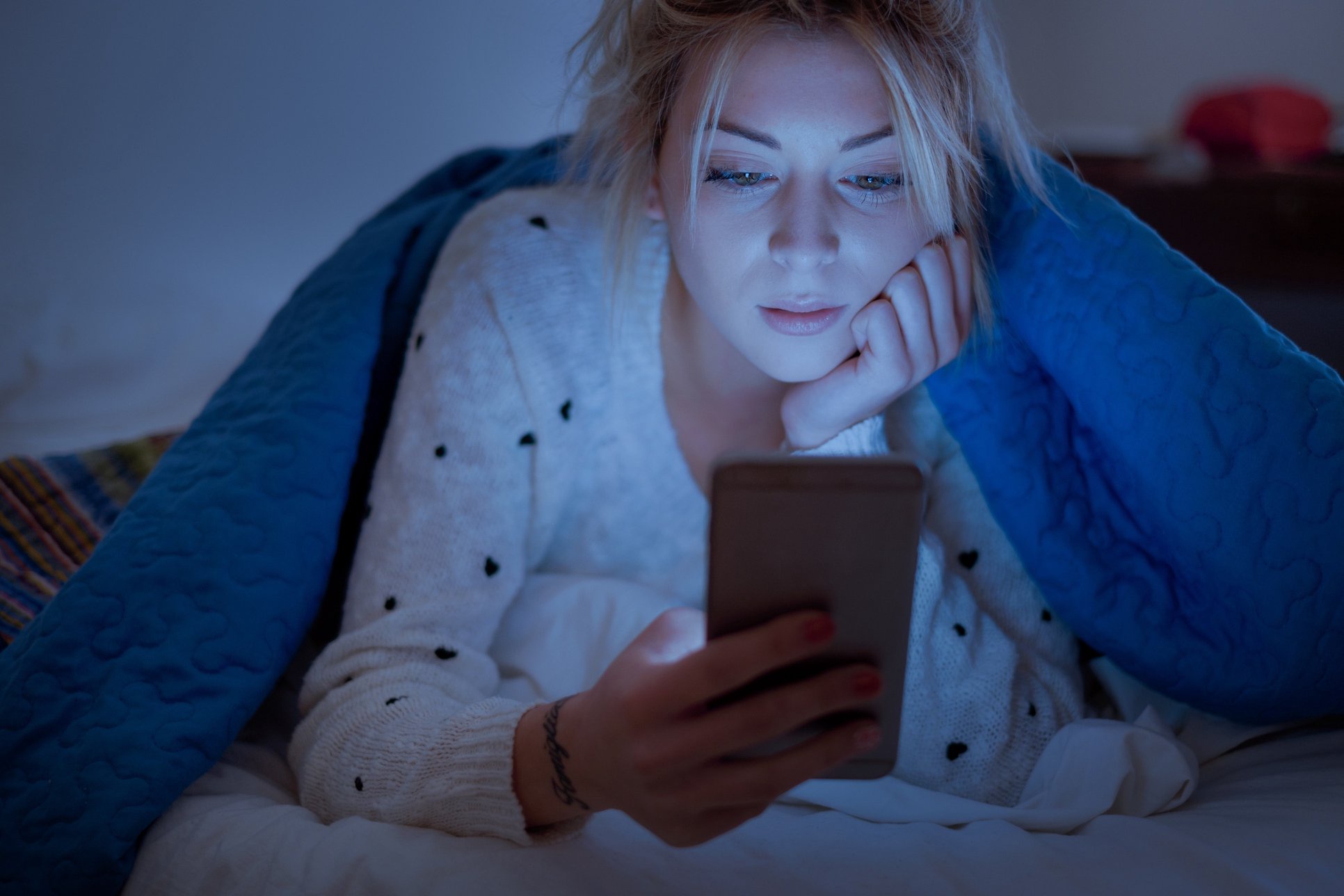 woman on phone in bed
