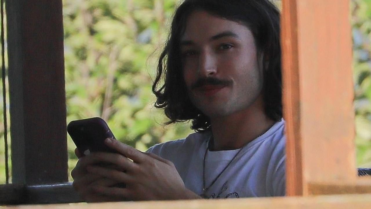 EXCLUSIVE: Scandal-plagued Ezra Miller smiles and lounges on mother's Vermont porch in first photos of the star since it was revealed the actor reshot scenes for The Flash and a day after third arrest