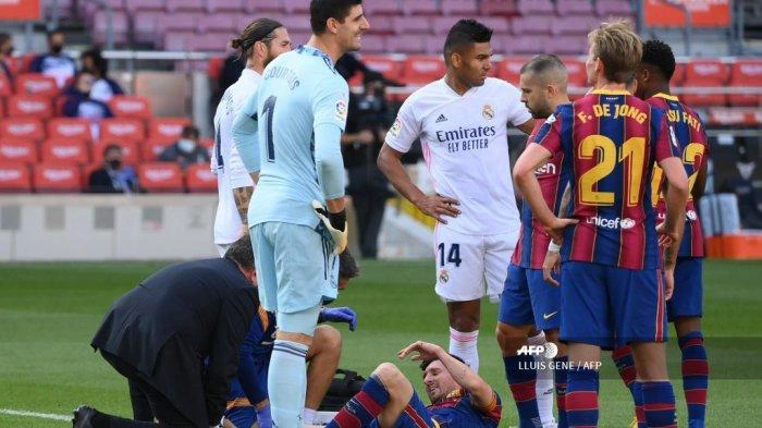 Penyerang Barcelona asal Argentina Lionel Messi menerima perawatan medis setelah terjatuh dalam pertandingan sepak bola Liga Spanyol antara Barcelona dan Real Madrid di stadion Camp Nou di Barcelona pada 24 Oktober 2020.
LLUIS GENE / AFP