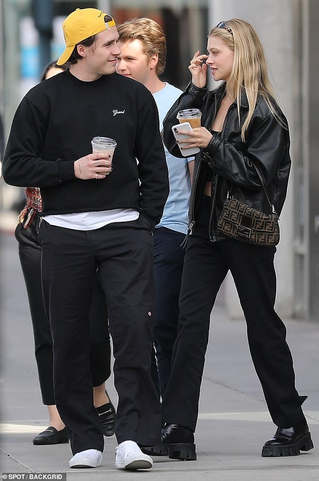 Chic style: His girlfriend looked stylish herself in an oversized leather jacket and tiny Fendi purse