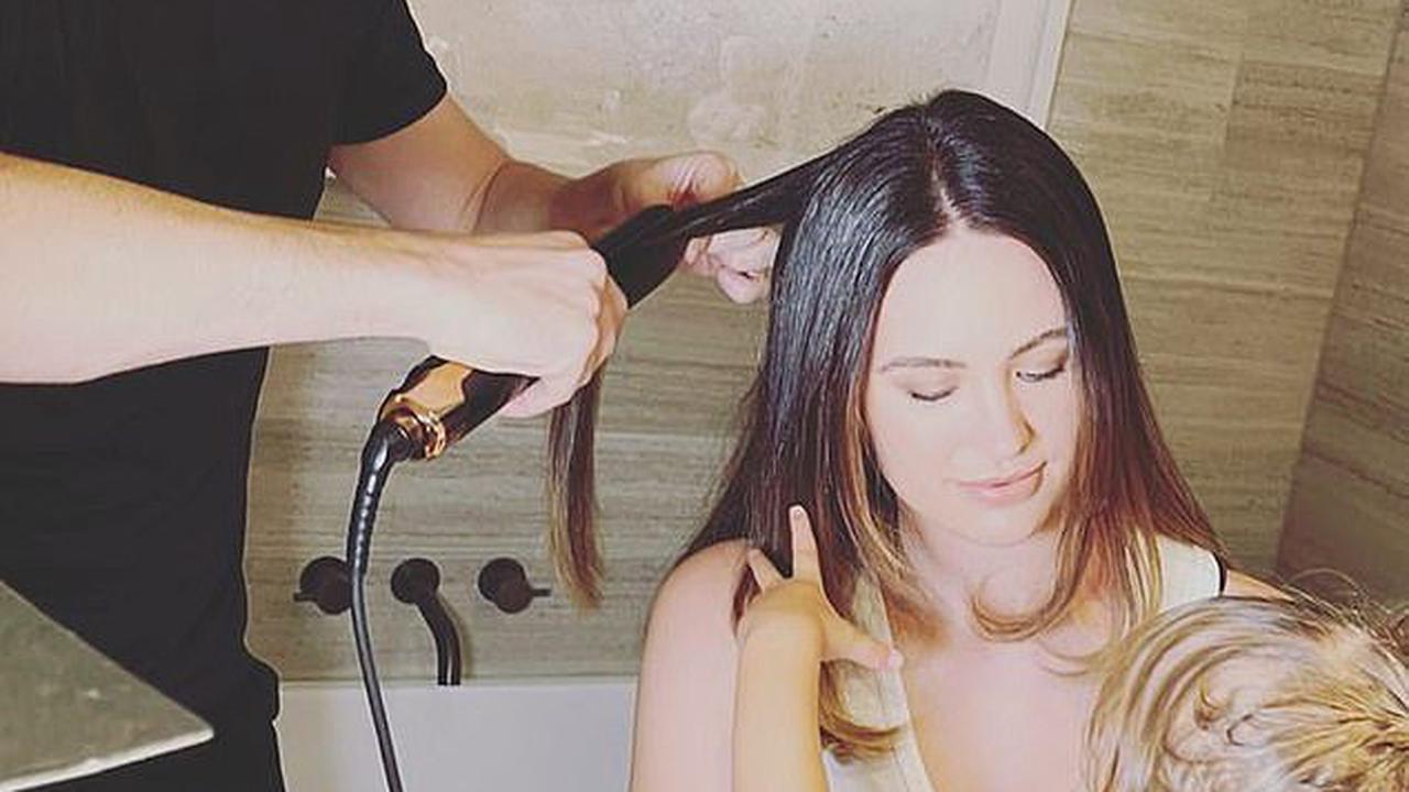 Jesinta Franklin shares a rare photo with her 21-month-old daughter Tullulah sitting on her lap as she gets her hair styled at home