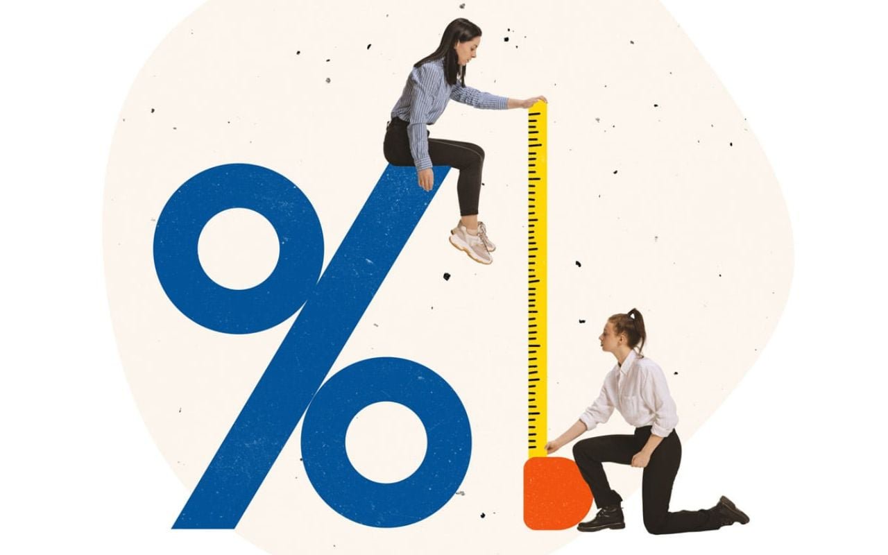 Two women measure a percentage sign.