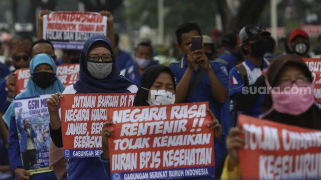 Sejumlah massa dari sejumlah elemen membentangkan poster saat melakukan aksi unjuk rasa di sekitar gedung DPR/MPR RI, Senayan, Jakarta, Kamis (14/8/2020). [Suara.com/Angga Budhiyanto]