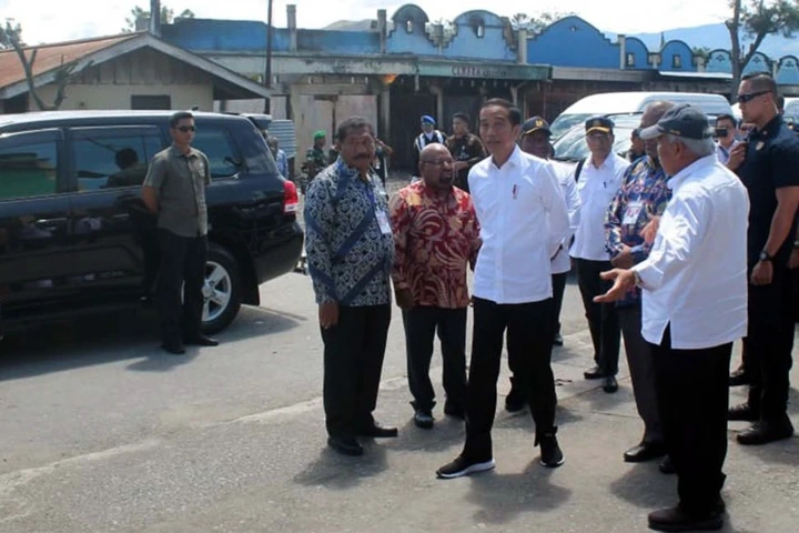 Presiden Joko Widodo mengamati bangunan yang terbakar saat kerusuhan lalu di Kantor Bupati Jayawijaya, Wamena, Papua, Senin (28/10).  [ANTARA FOTO/Anyong]