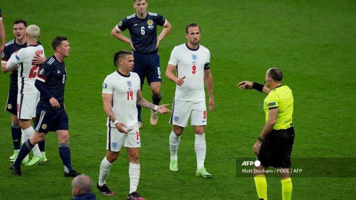 Gelandang Inggris Kalvin Phillips dan penyerang Inggris Harry Kane berbicara dengan wasit Spanyol Antonio Mateu Lahoz selama pertandingan sepak bola Grup D UEFA EURO 2020 antara Inggris dan Skotlandia di Stadion Wembley di London pada 18 Juni 2021.
Matt Dunham / POOL / AFP