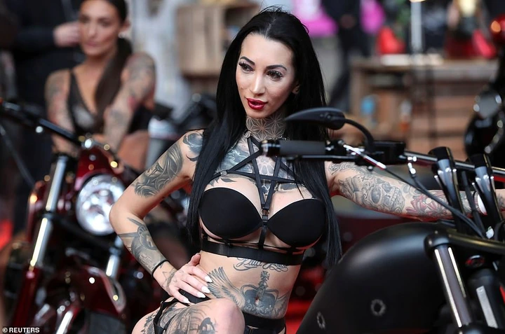 Dozens of tattoo-supply stores have set up stalls at the convention to sell to the hundreds of people that attend. Pictured: One scantily-clad, tattooed model posed on a motorcycle at one of the bike shows