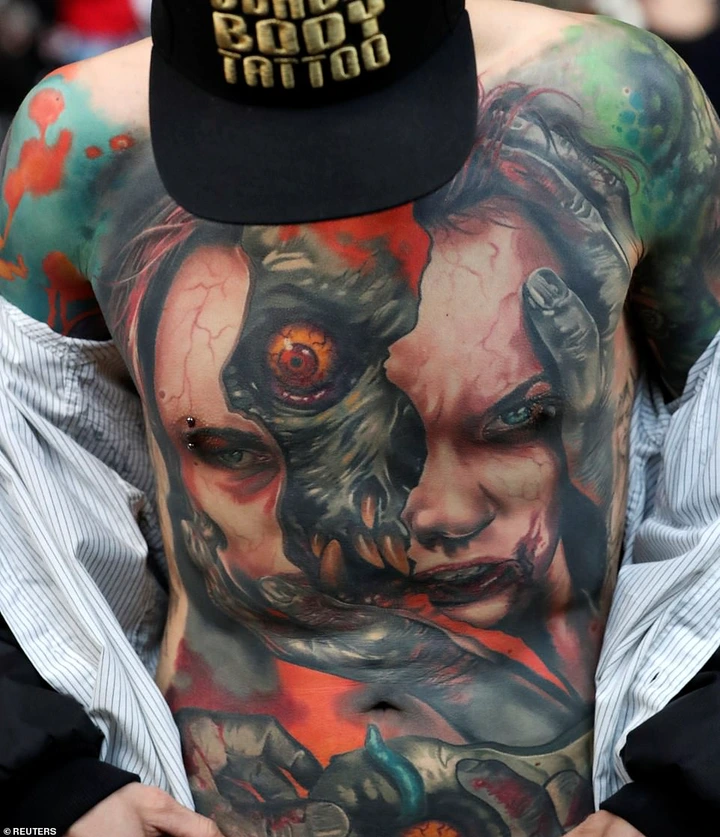 Tattoo artists and aficionados from across the globe, including from Bosnia, Croatia and Lithuania, all descended on the convention in Brussels. Pictured: One man displays a nipple piercing along with his full-body, colour tattoo of a face being torn in two