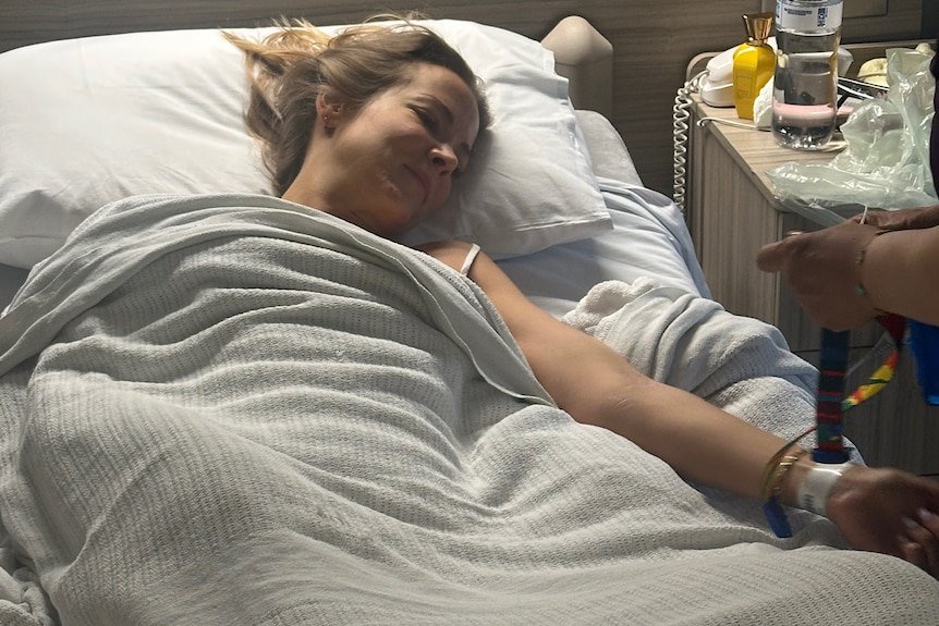 Megan Hancocks in a hospital bed recovering from acute liver failure.