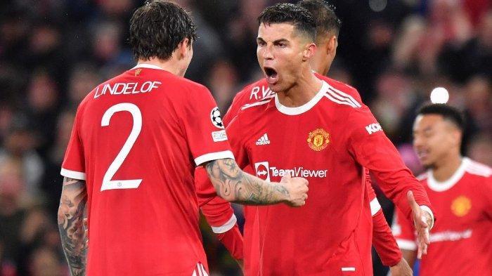 Striker Manchester United asal Portugal Cristiano Ronaldo (tengah) merayakan dengan bek Manchester United asal Swedia Victor Lindelof pada peluit akhir dalam pertandingan sepak bola grup F Liga Champions UEFA antara Manchester United dan Villarreal di stadion Old Trafford di Manchester, barat laut Inggris, pada 29 September, 2021. Manchester United memenangkan pertandingan dengan skor 2-1.
Anthony Devlin / AFP