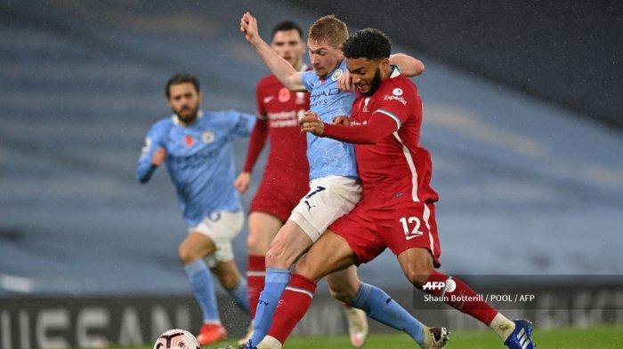 Bek Inggris Liverpool Joe Gomez (kanan) persembunyian gelandang Belgia Manchester City Kevin De Bruyne (tengah) selama pertandingan sepak bola Liga Utama Inggris antara Manchester City dan Liverpool di Stadion Etihad di Manchester, barat laut Inggris, pada 8 November 2020.
Shaun Botterill / POOL / AFP