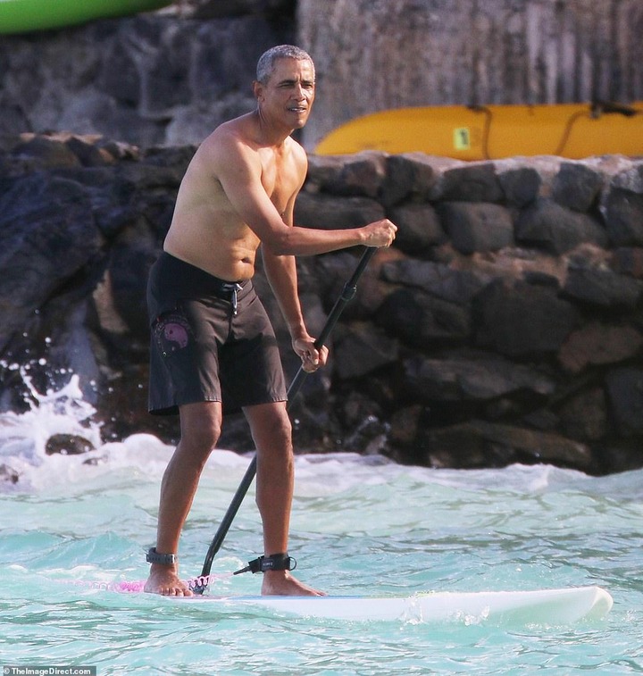 Shirtless Barack Obama shows off his fit physique during a paddle board session while on vacation in Hawaii (Photos)