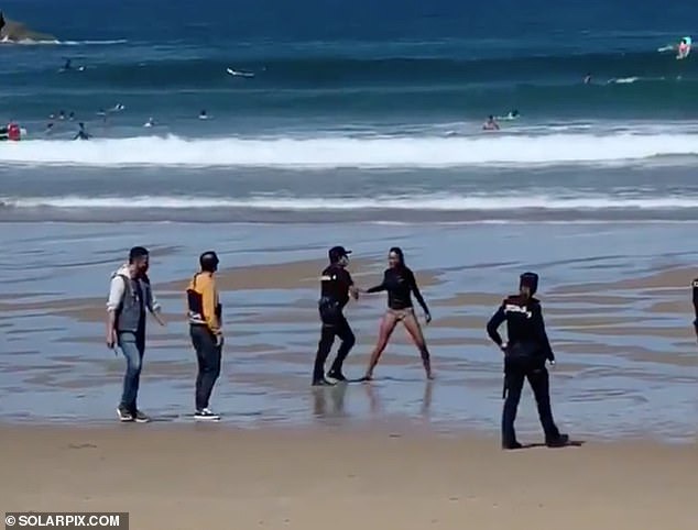 Female surfer is dragged away by hamzat-officials and arrested on Spanish beach after going in the sea while infected with COVID-19 (photos)