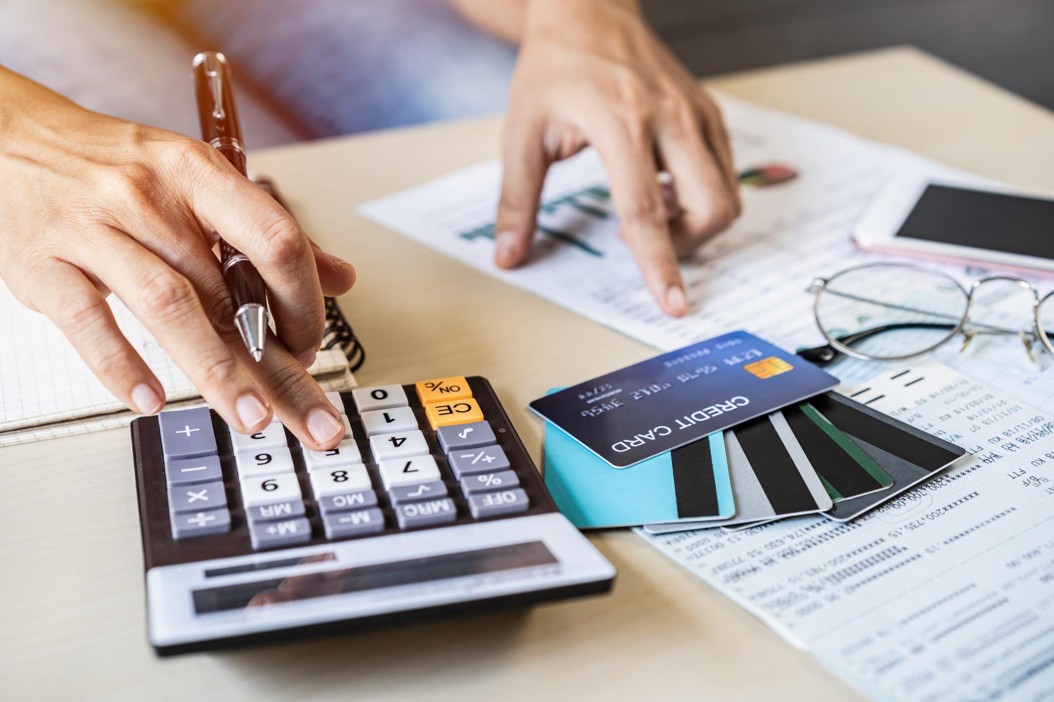 A young woman checking bills, taxes, bank account balance and calculating credit card expenses at home.